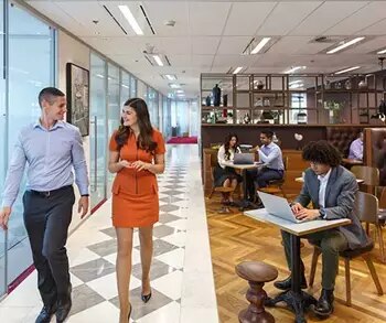 Coworking space in Servcorp were a receptionist is showing the client around. 